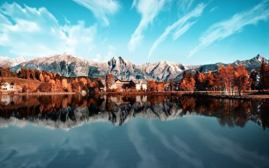 Der Wildsee in Seefeld, Tirol, umgeben von herbstlichen Bäumen und Berglandschaften, die sich im ruhigen Wasser spiegeln.